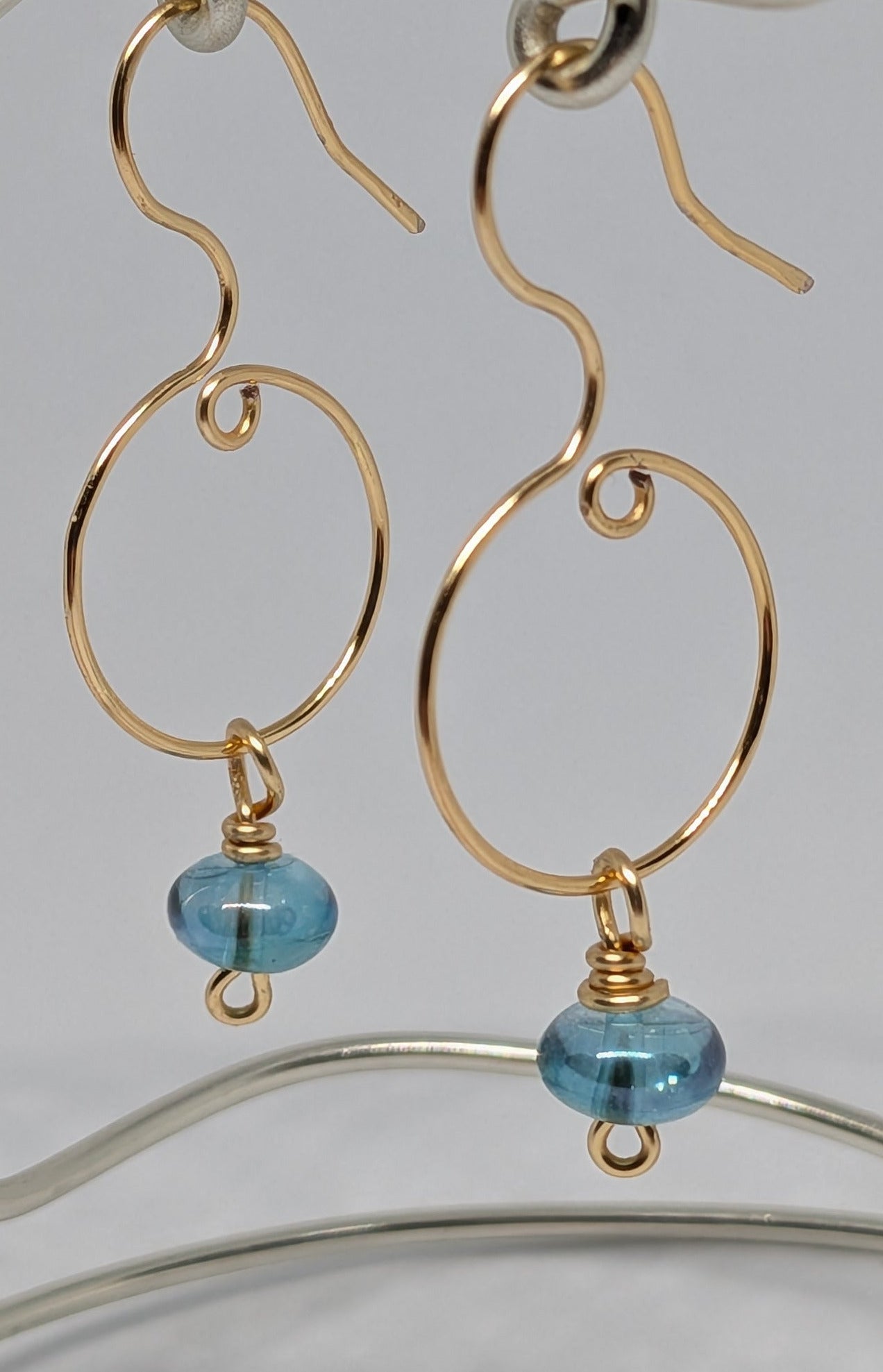 Blaue Glasperlen auf goldfarbenen Draht