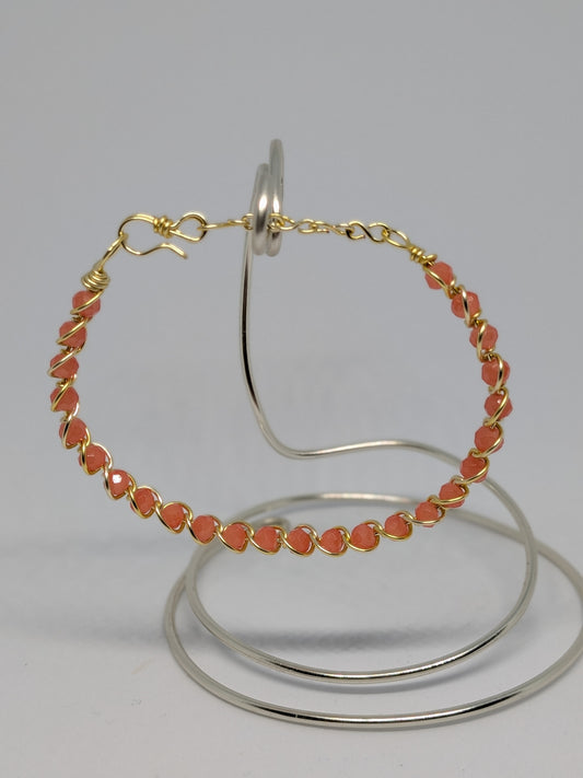 Elegantes Armband in Hellgold mit geschliffenen orangefarbenen Glasperlen