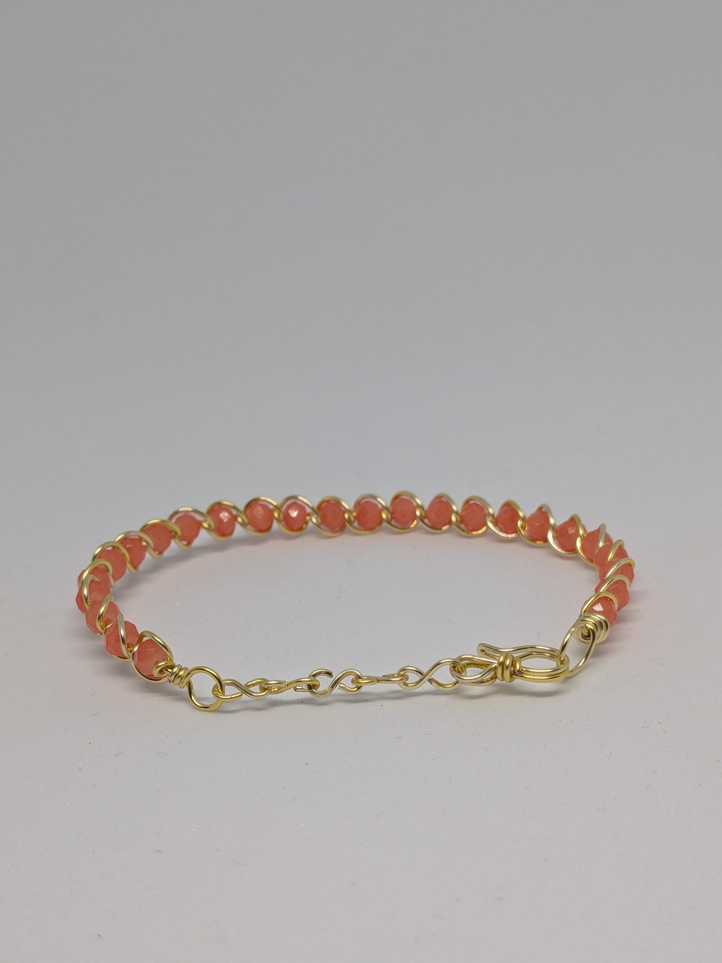 Elegantes Armband in Hellgold mit geschliffenen orangefarbenen Glasperlen
