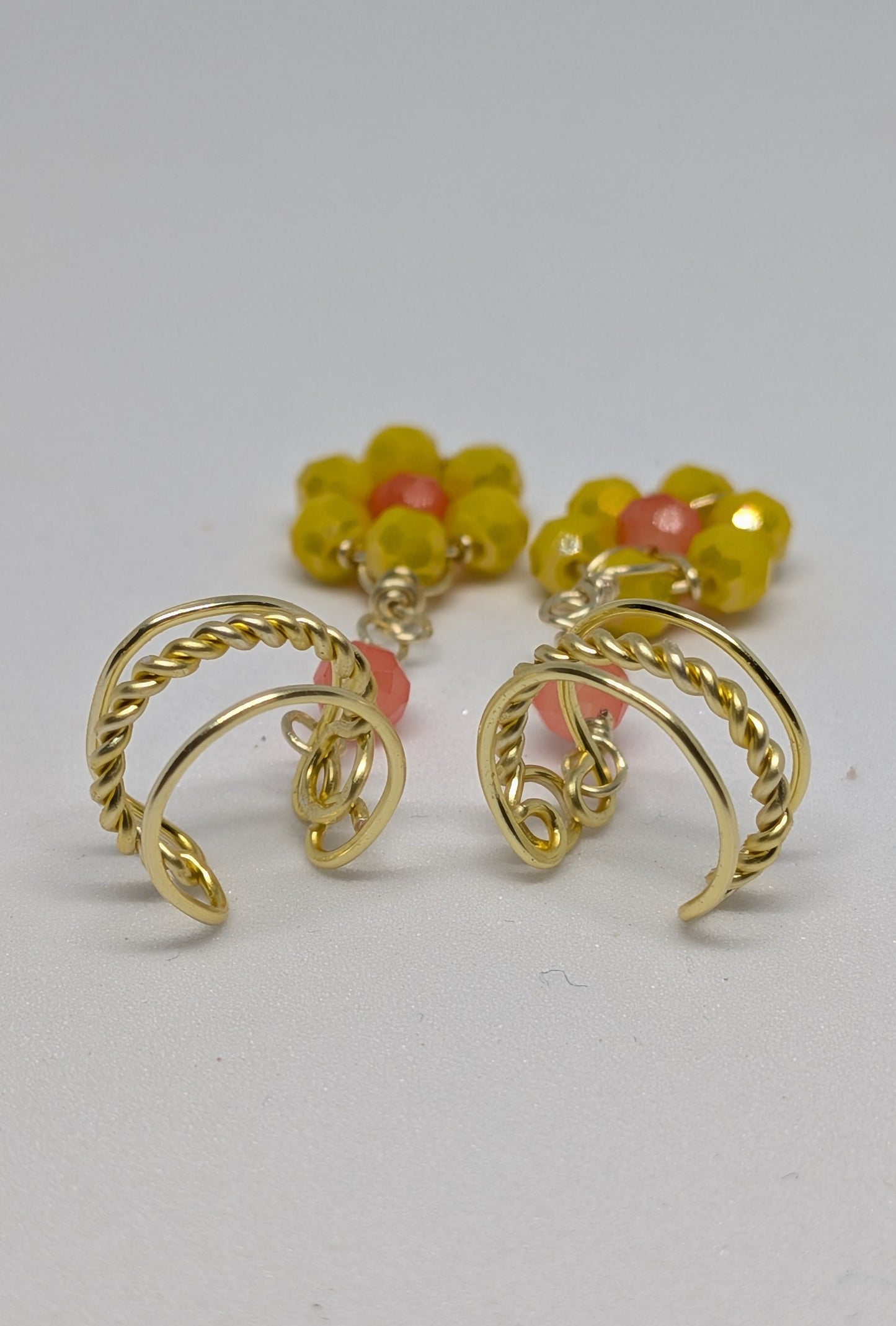 Ein Paar Earcuffs in Hellgold mit Blumenanhänger in sommerlich leuchtendem Gelb
