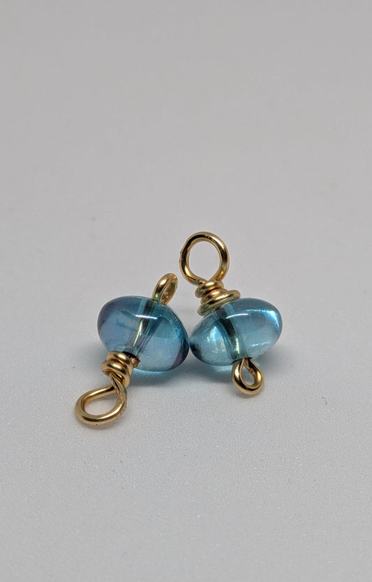 Blaue Glasperlen auf goldfarbenen Draht