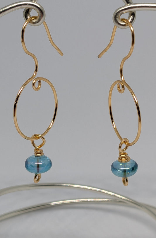 Blaue Glasperlen auf goldfarbenen Draht