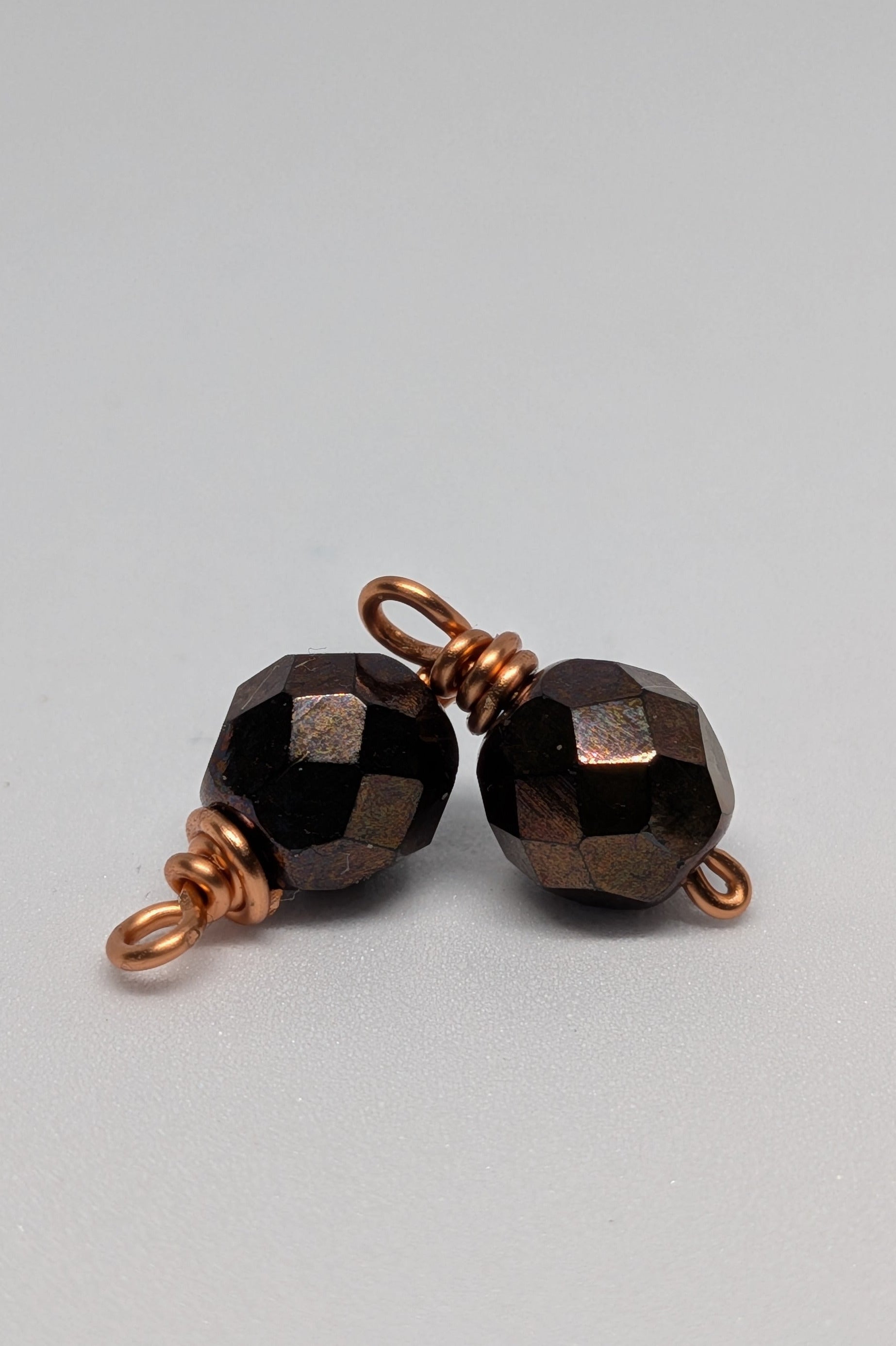 Dunkle Glasperlen auf kupferfarbenen Draht