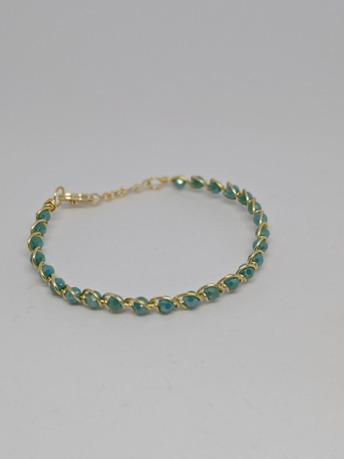 Elegantes Armband in Hellgold mit geschliffenen türkisen Glasperlen