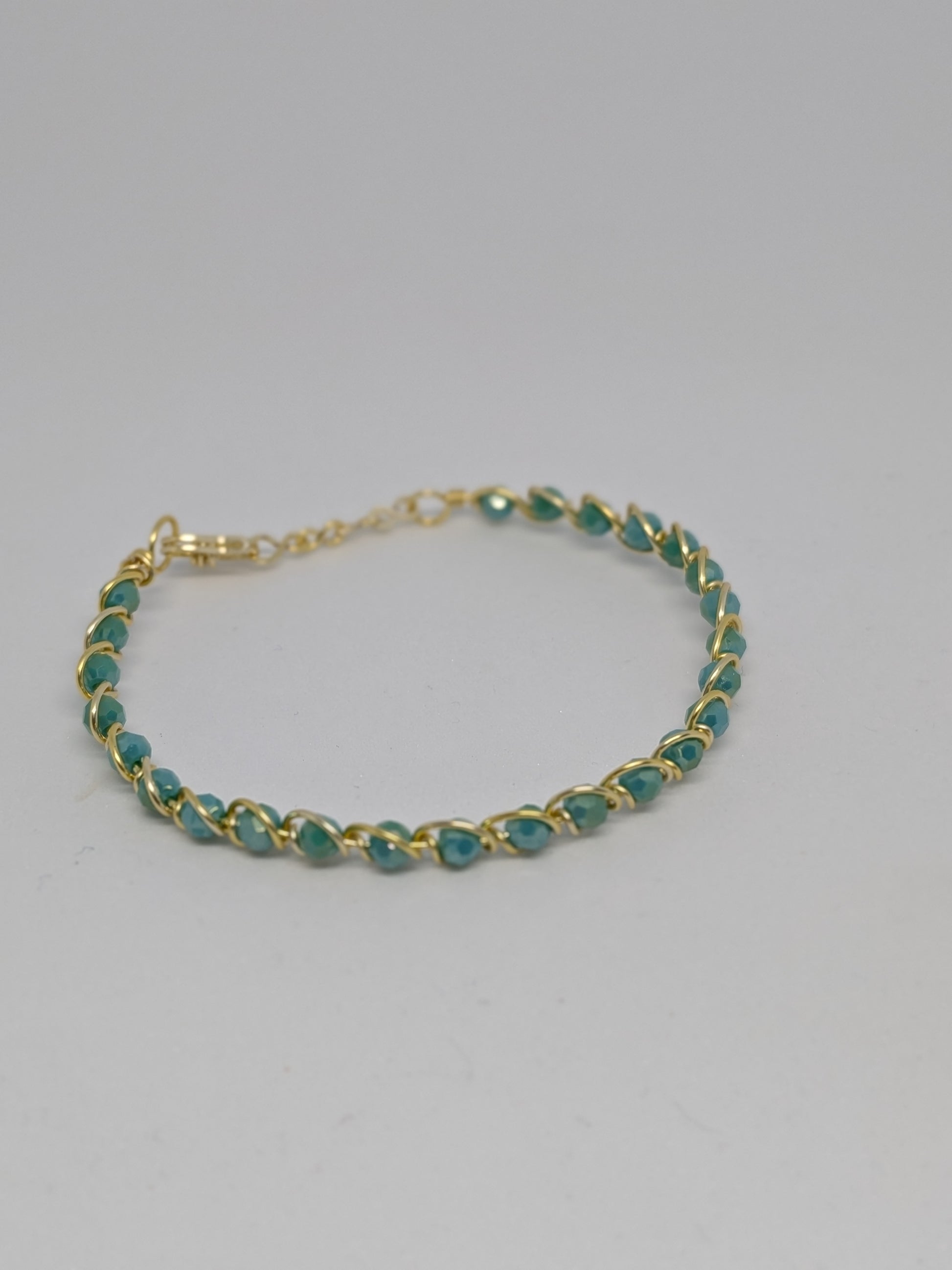 Elegantes Armband in Hellgold mit geschliffenen türkisen Glasperlen