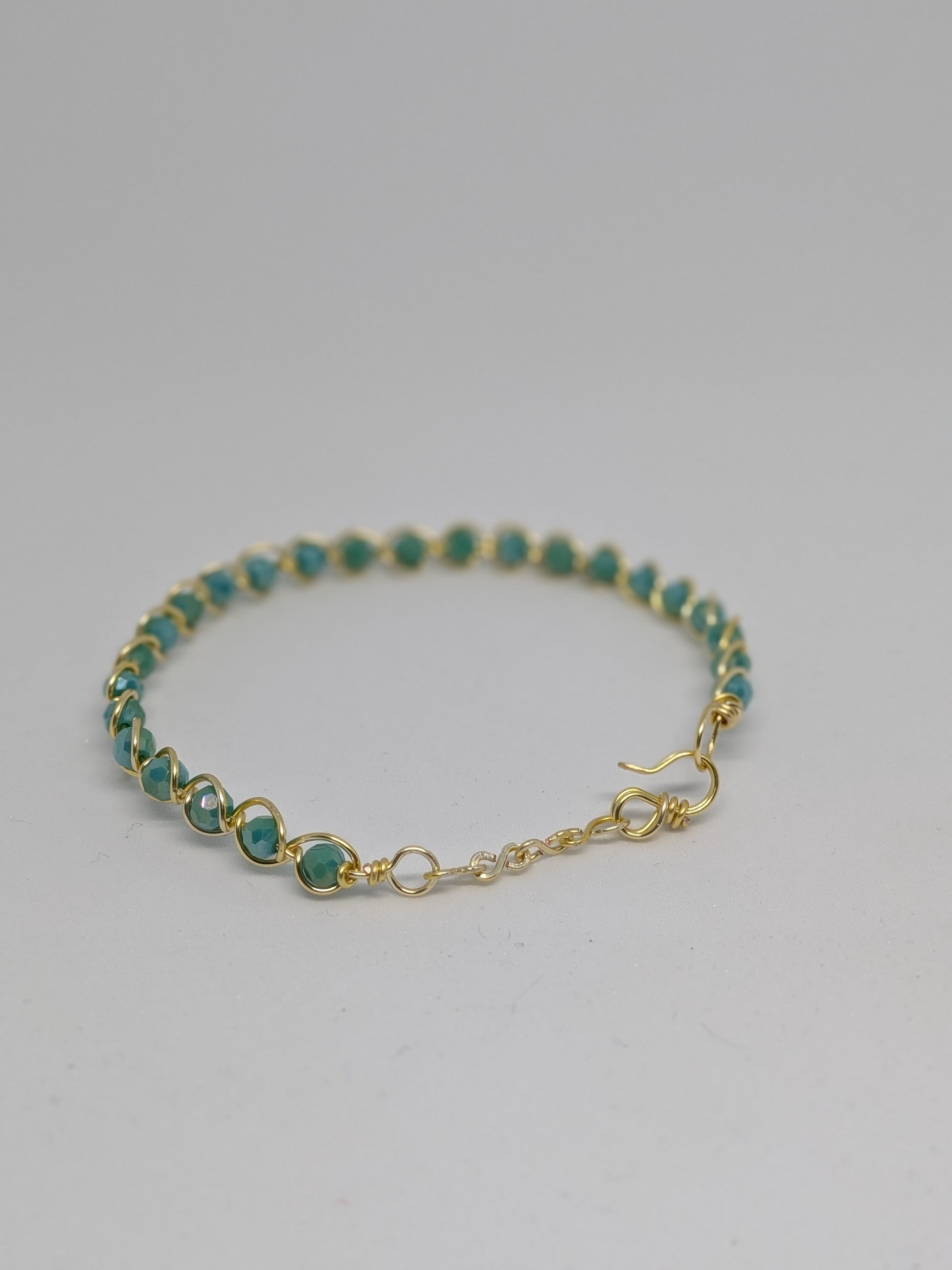 Elegantes Armband in Hellgold mit geschliffenen türkisen Glasperlen