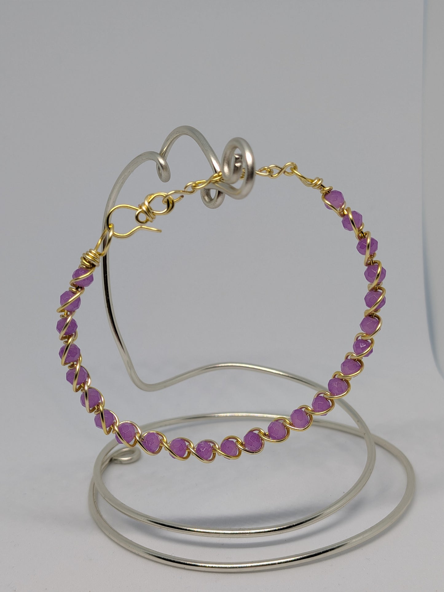 Elegantes, hellgoldfarbenes Armband mit geschliffenen fliederfarbenen Glasperlen. 