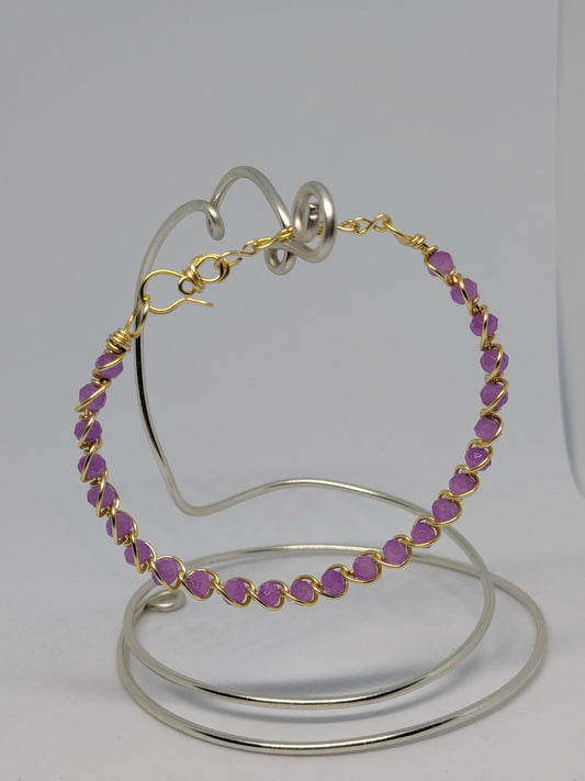 Elegantes, hellgoldfarbenes Armband mit geschliffenen fliederfarbenen Glasperlen. 