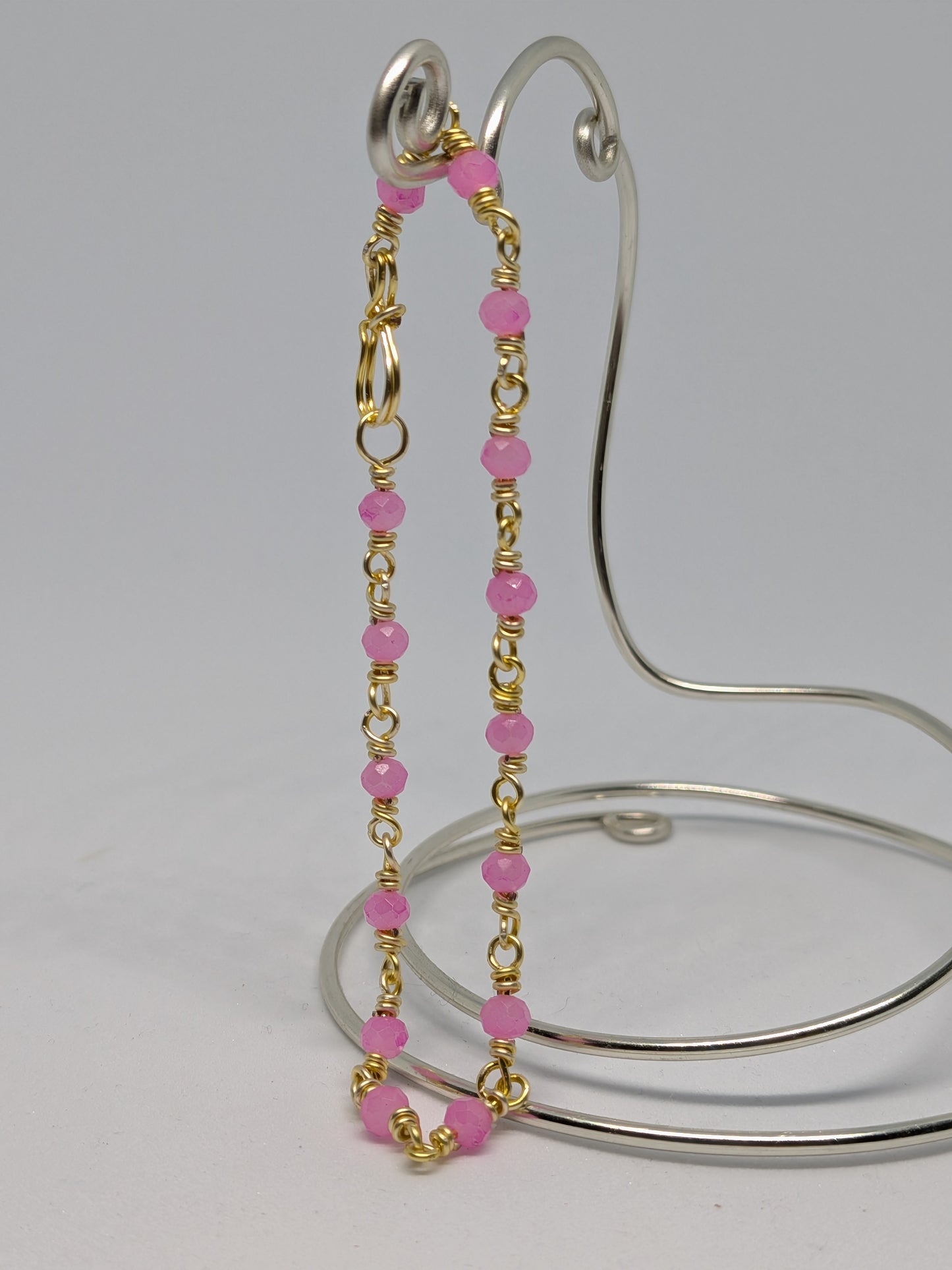 Elegantes Glieder-Armband in Hellgold mit geschliffenen pinken Glasperlen
