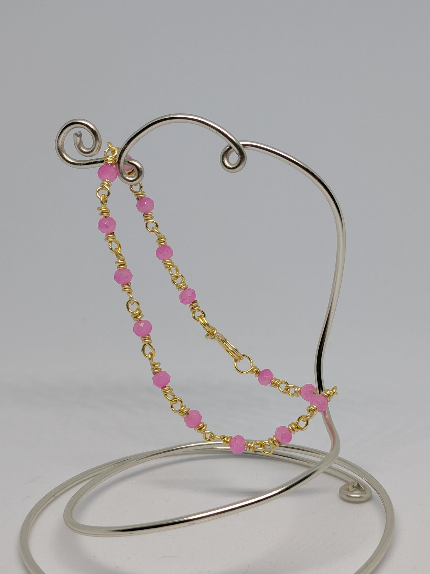 Elegantes Glieder-Armband in Hellgold mit geschliffenen pinken Glasperlen