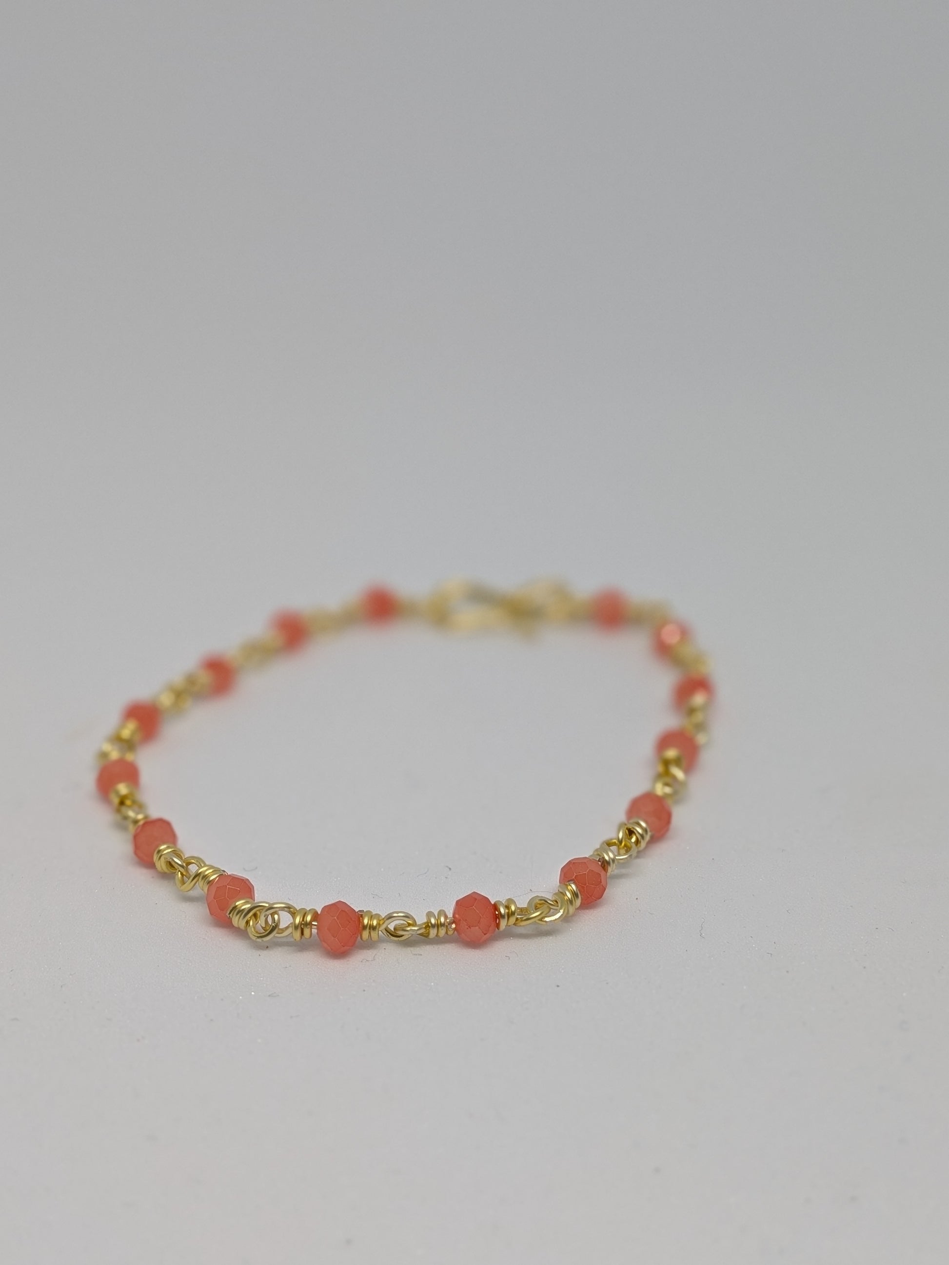 Elegantes Glieder-Armband in Hellgold mit geschliffenen orangefarbenen Glasperlen