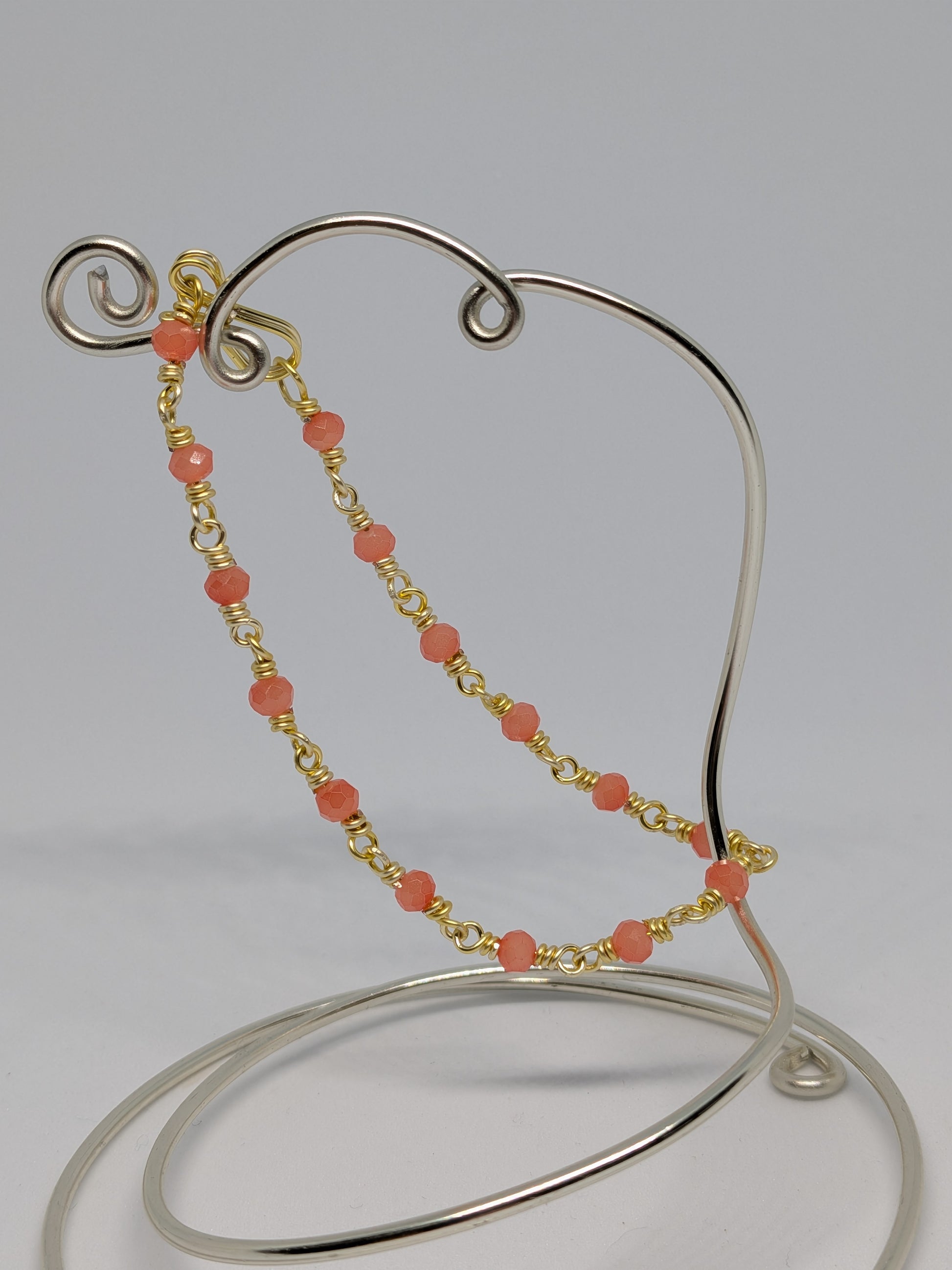 Elegantes Glieder-Armband in Hellgold mit geschliffenen orangefarbenen Glasperlen