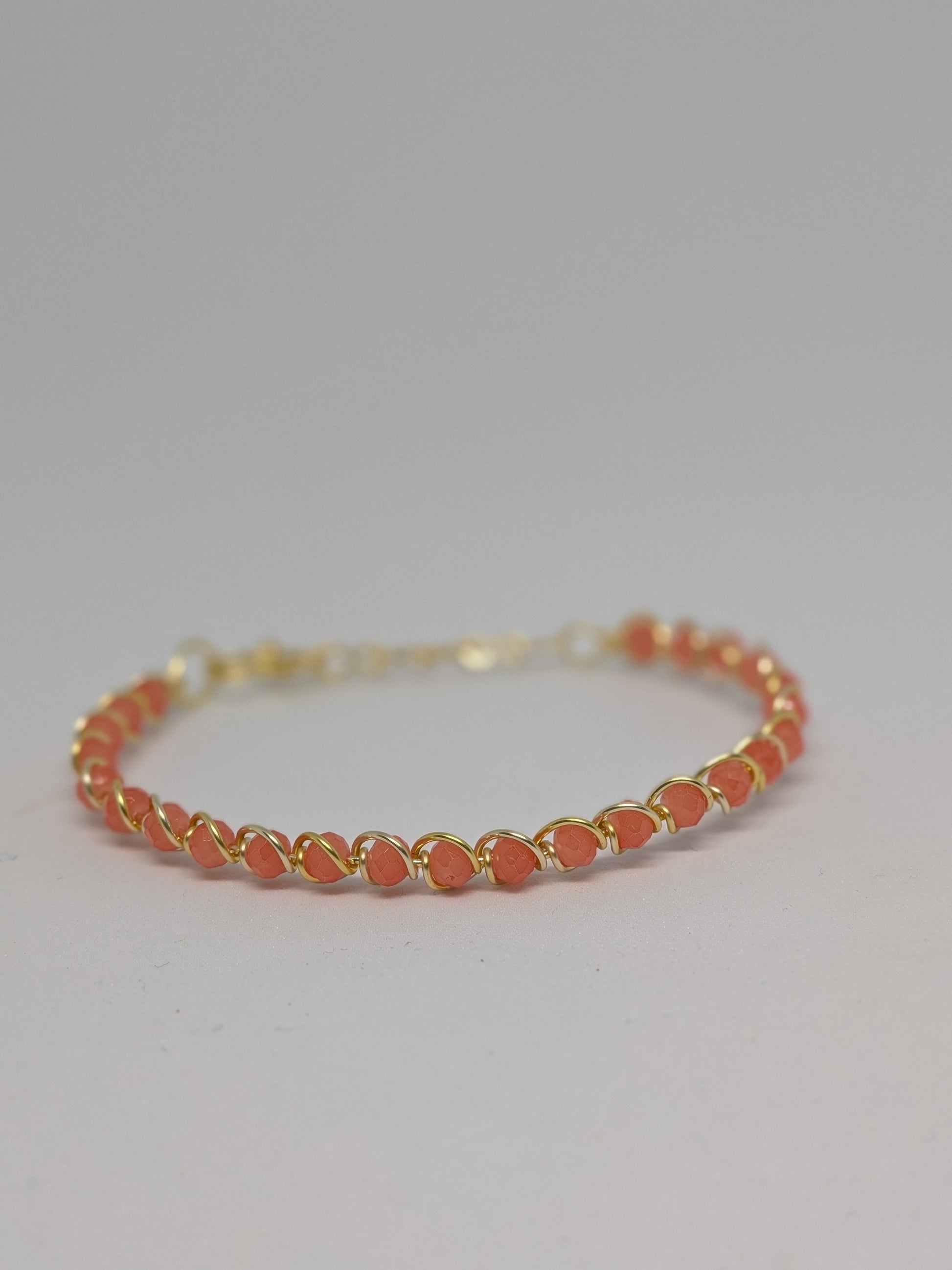 Elegantes Armband in Hellgold mit geschliffenen orangefarbenen Glasperlen
