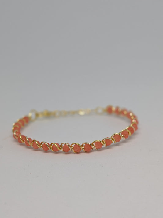 Elegantes Armband in Hellgold mit geschliffenen orangefarbenen Glasperlen