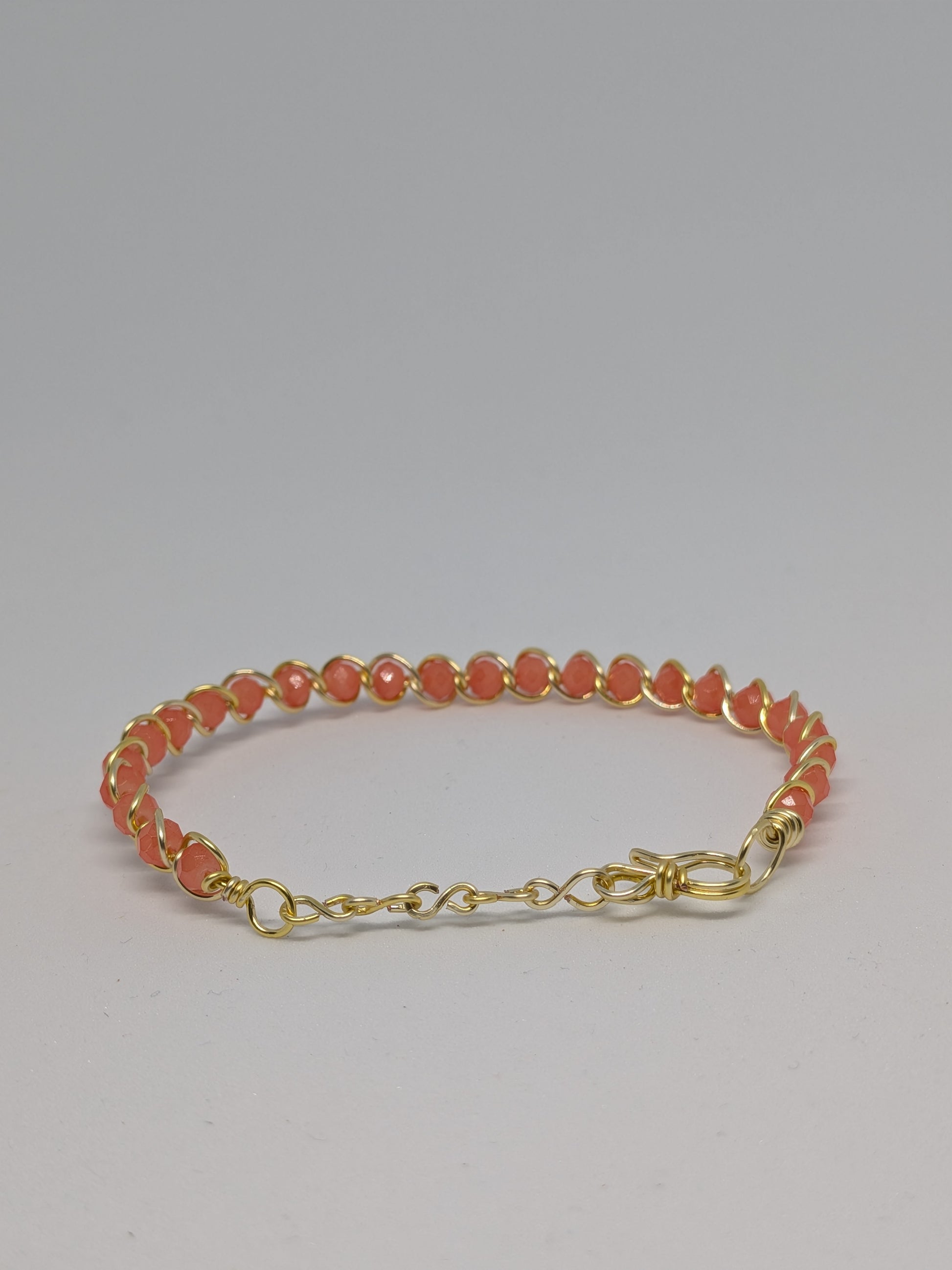 Elegantes Armband in Hellgold mit geschliffenen orangefarbenen Glasperlen
