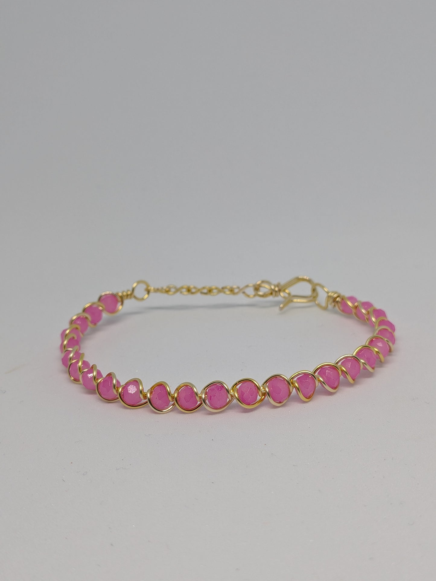 Elegantes Armband in Hellgold mit geschliffenen pinken Glasperlen