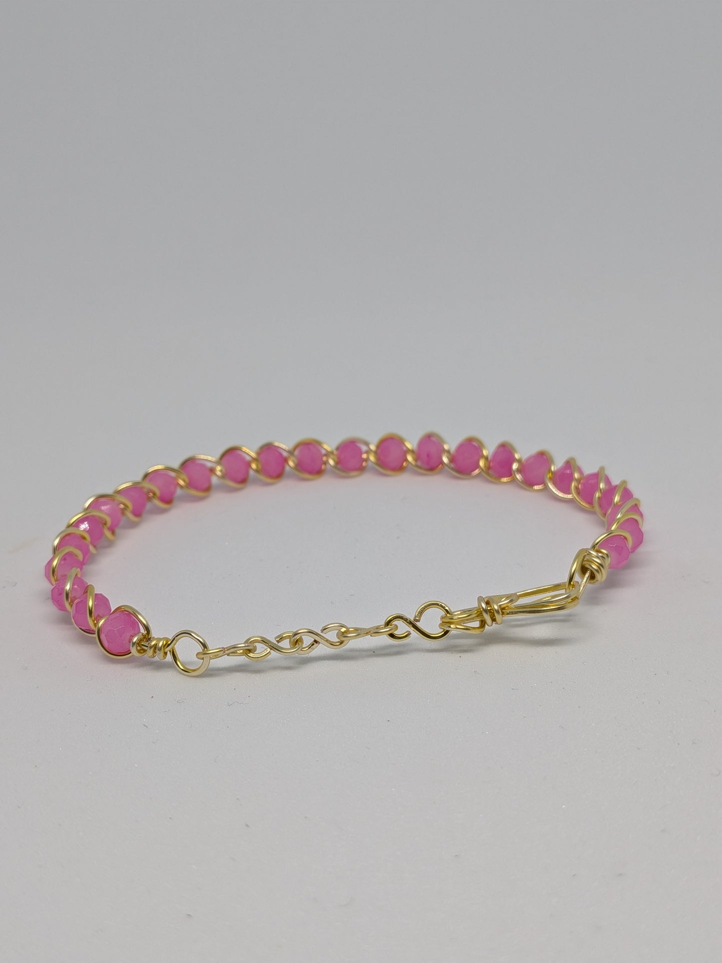 Elegantes Armband in Hellgold mit geschliffenen pinken Glasperlen