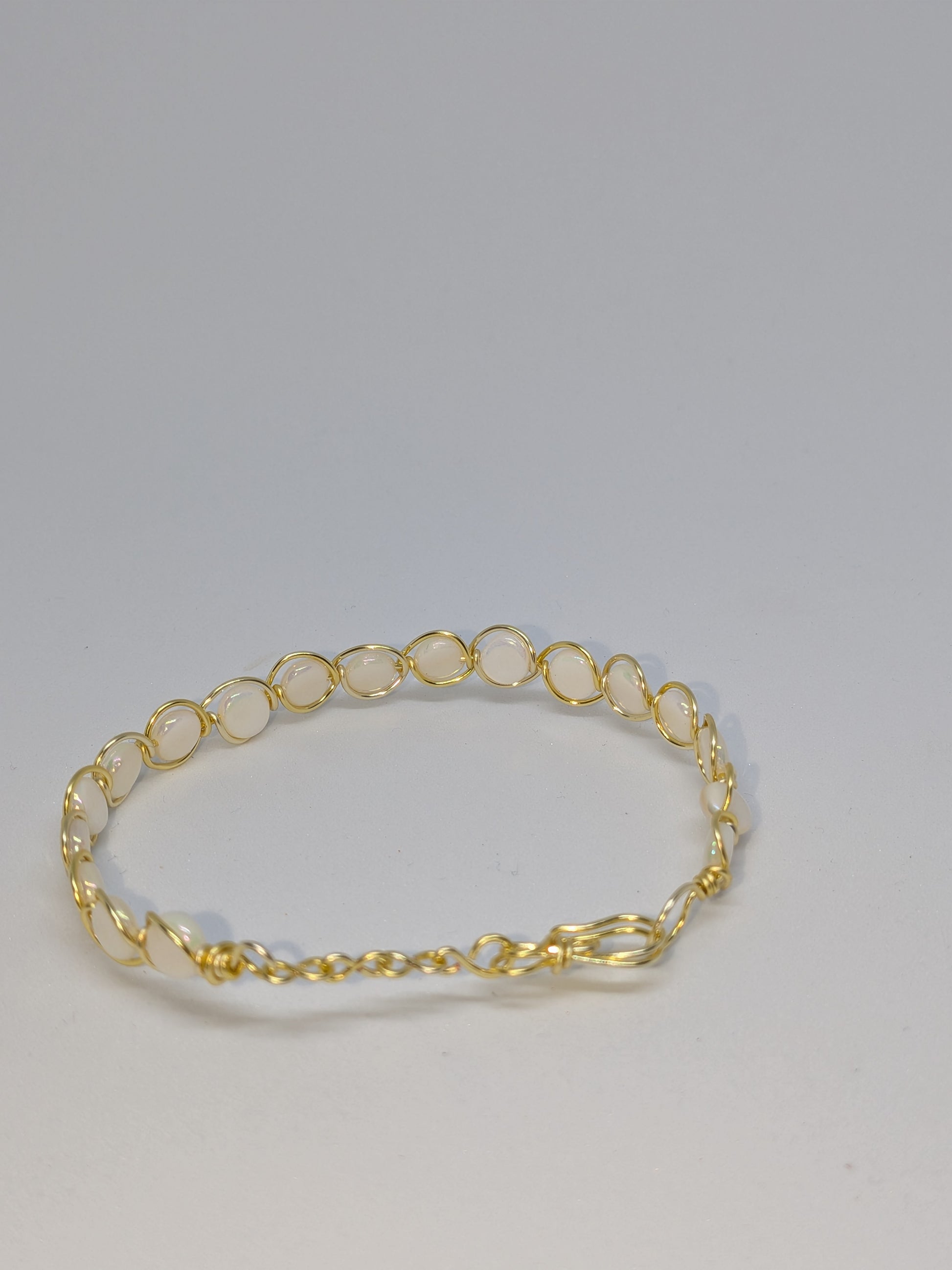 Elegantes Armband in Hellgold mit weißen Muschelperlen