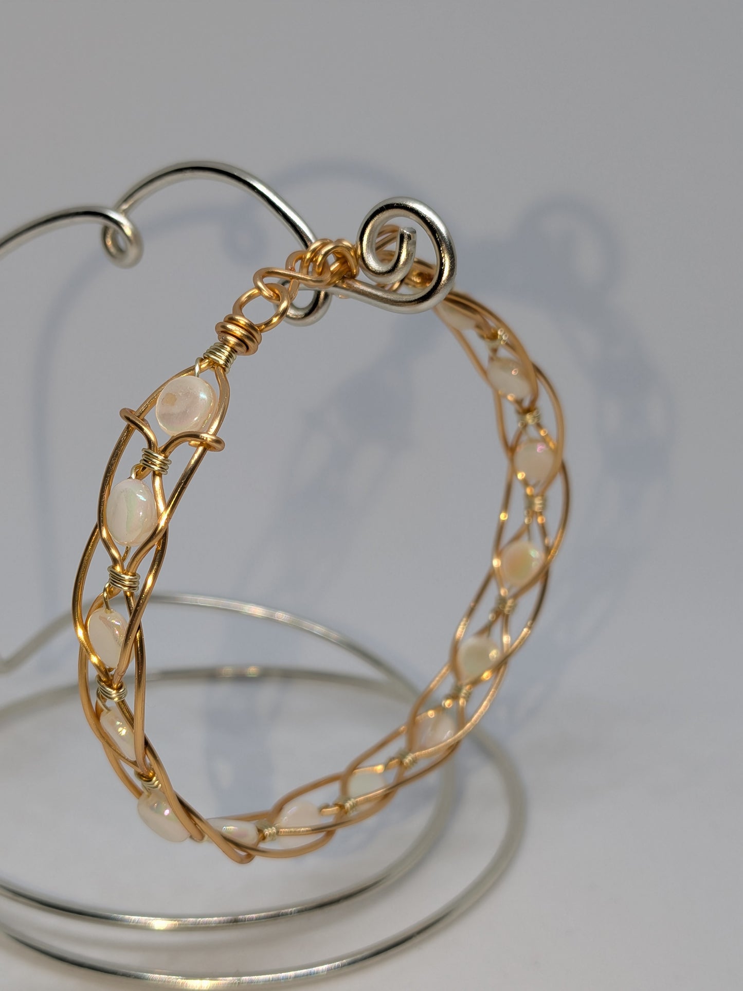 Geflochtenes goldfarbenes Armband mit weißen Muschelperlen