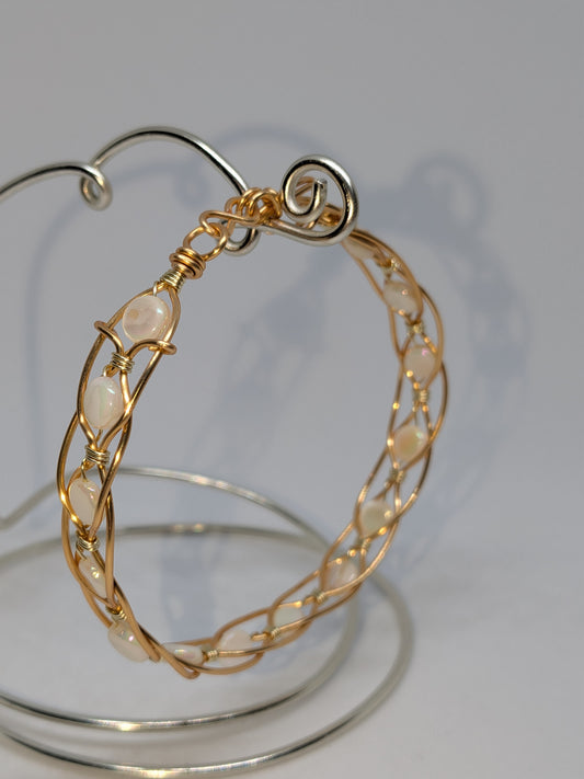 Geflochtenes goldfarbenes Armband mit weißen Muschelperlen