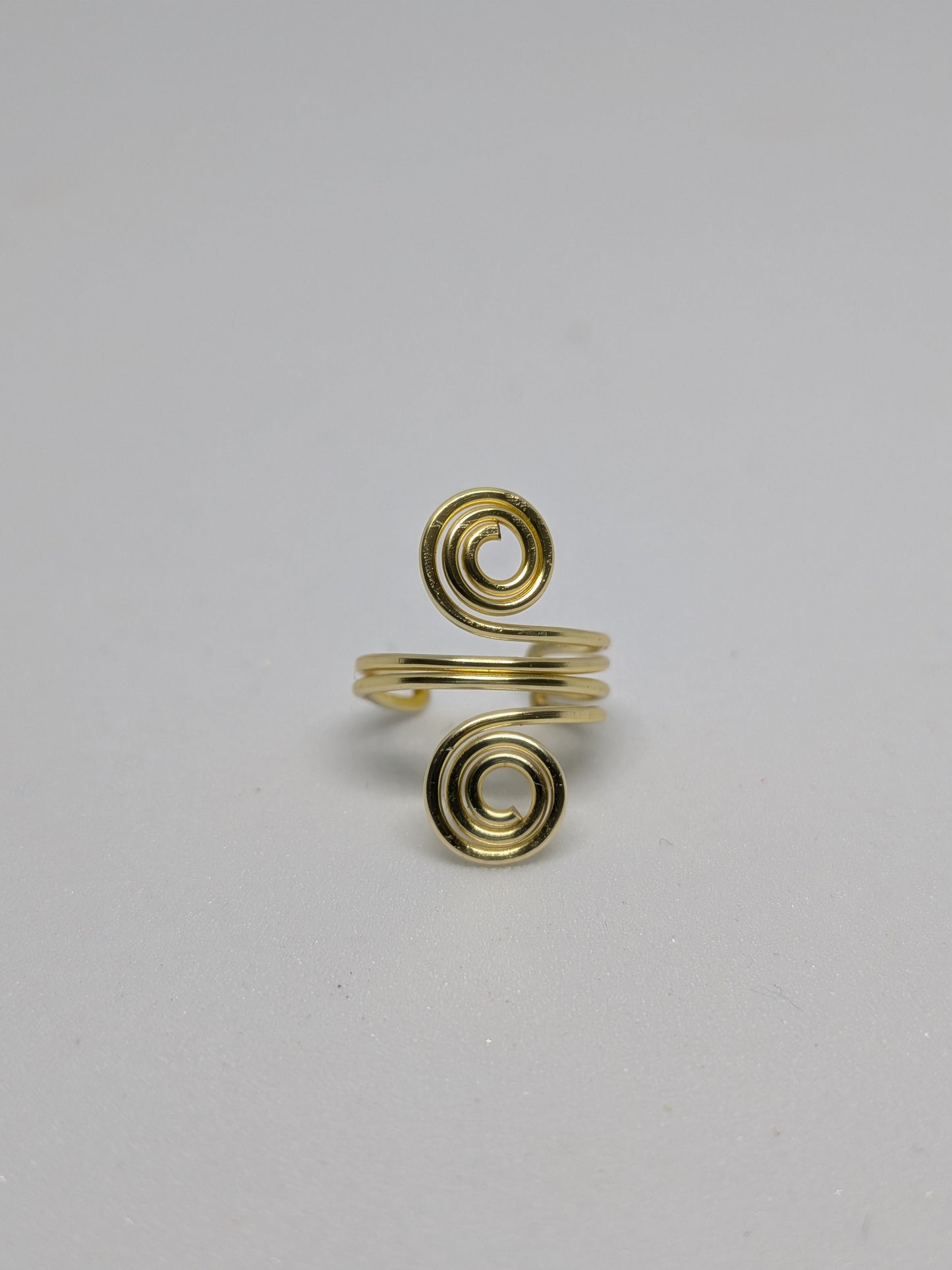 Einzelner Earcuff in Hellgold mit dekorativen Spiralen