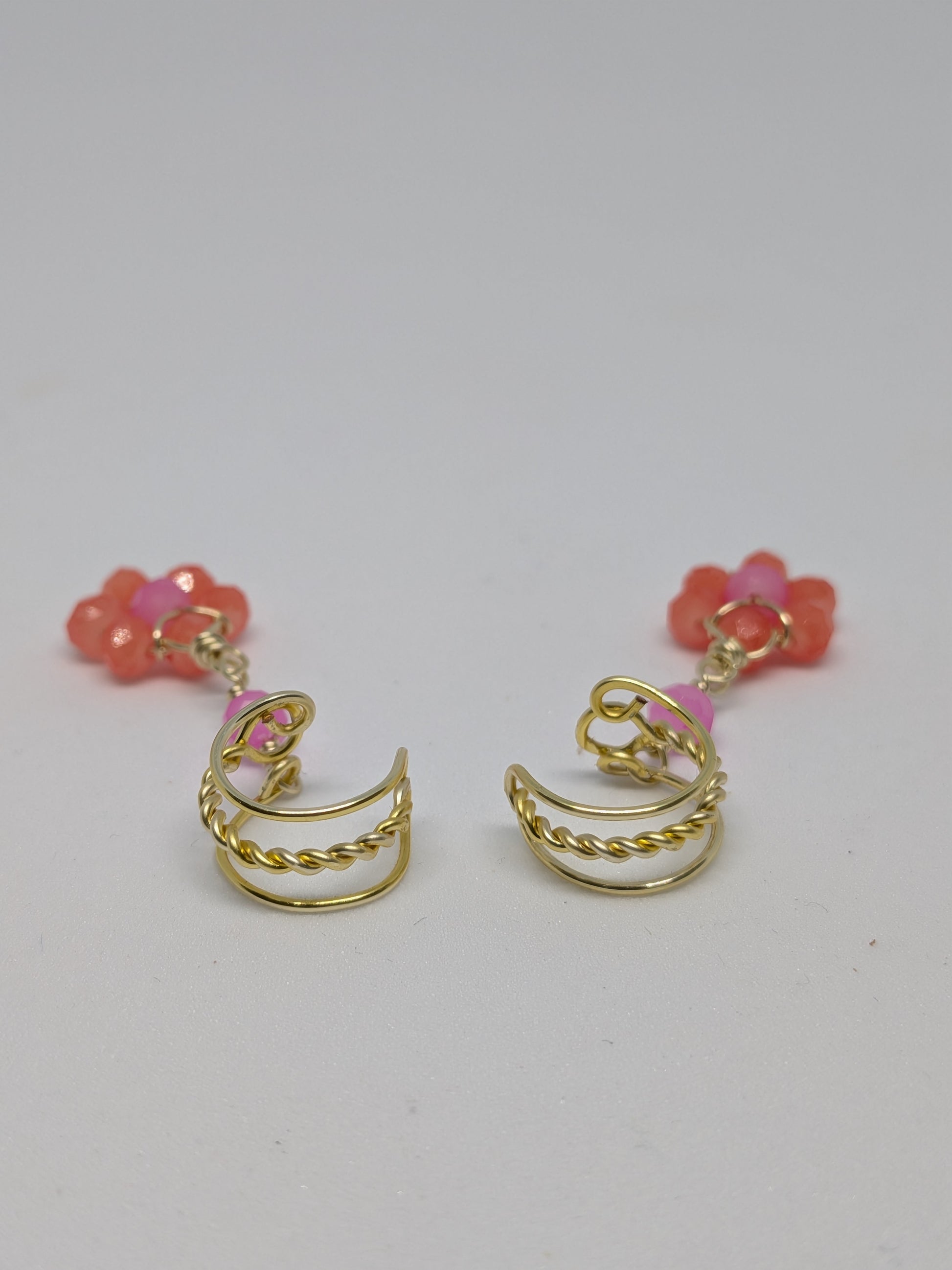 Ein Paar Earcuffs in Hellgold mit Blumenanhänger in sommerlich leuchtendem Orange 