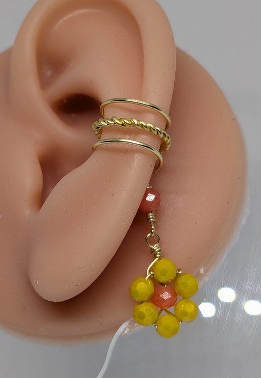 Ein Paar Earcuffs in Hellgold mit Blumenanhänger in sommerlich leuchtendem Gelb 