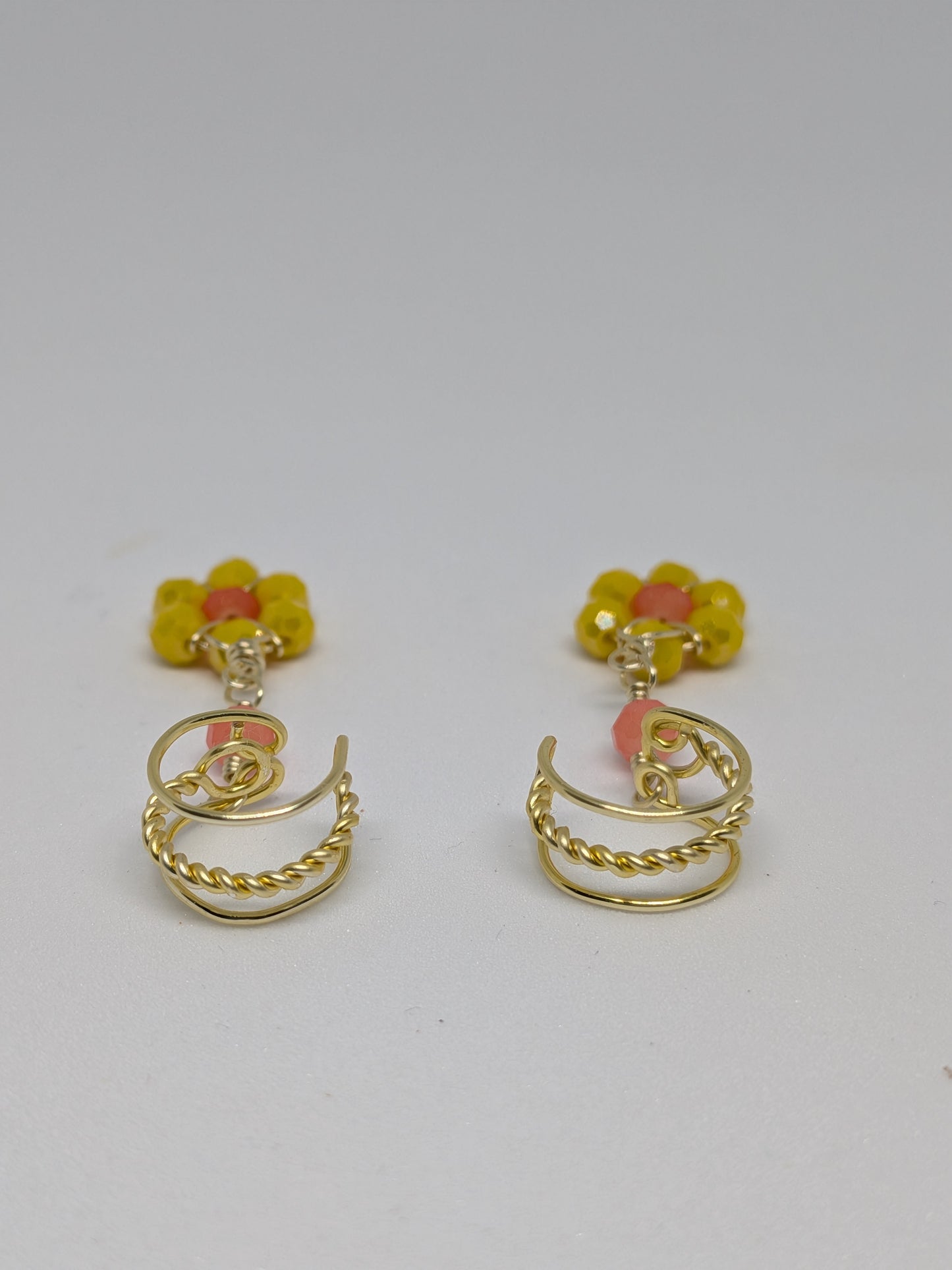 Ein Paar Earcuffs in Hellgold mit Blumenanhänger in sommerlich leuchtendem Gelb
