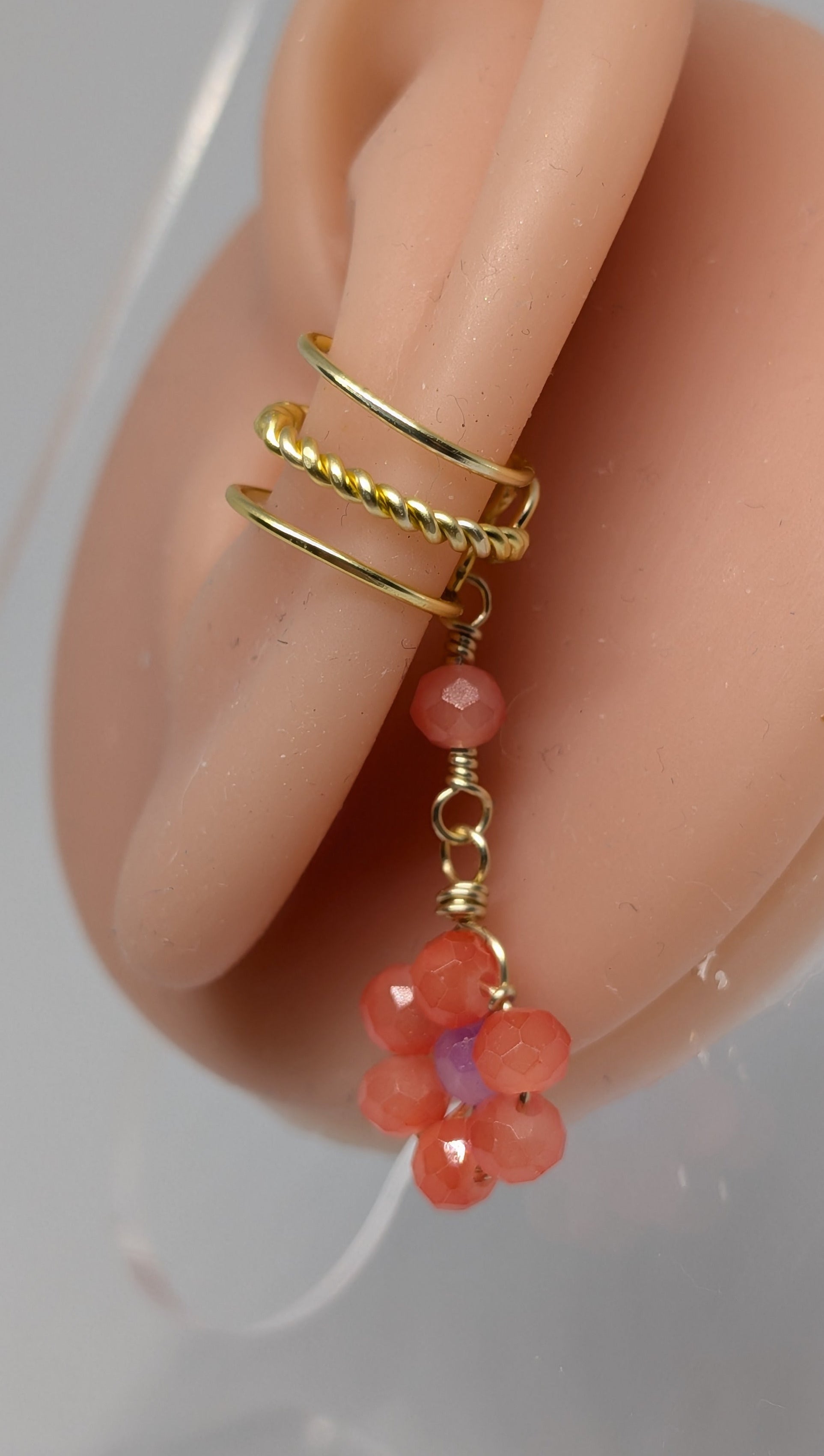 Ein Paar Earcuffs in Hellgold mit Blumenanhänger in sommerlich leuchtendem Orange