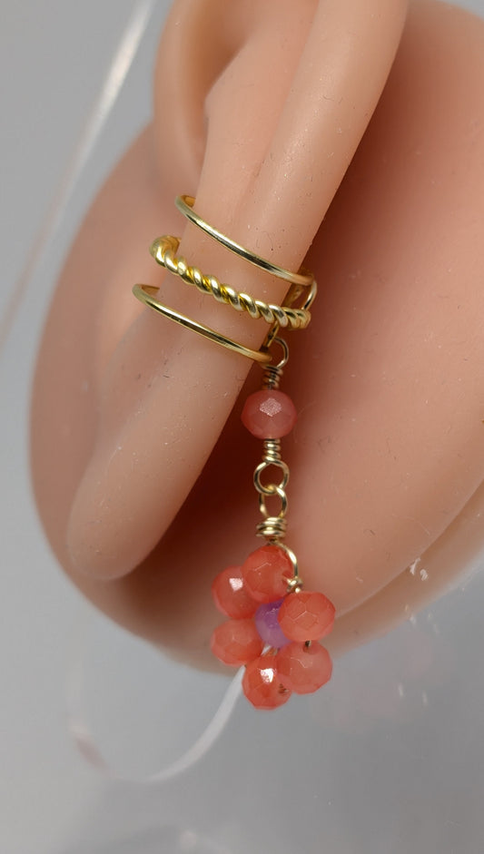 Ein Paar Earcuffs in Hellgold mit Blumenanhänger in sommerlich leuchtendem Orange