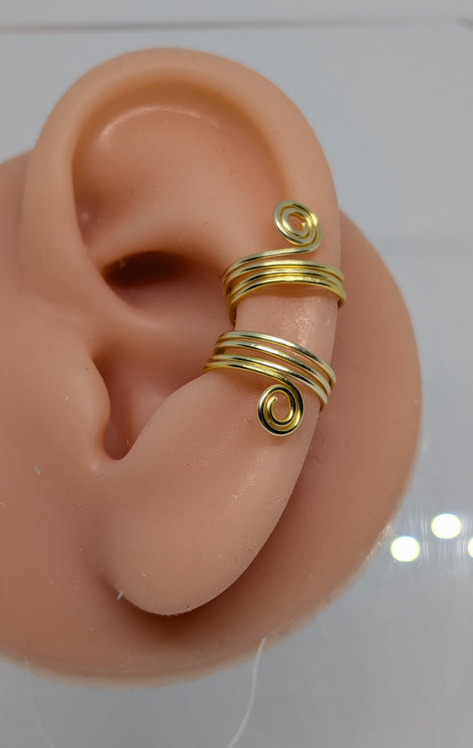 Ein Paar Earcuffs in Hellgold mit dekorativen Spiralen