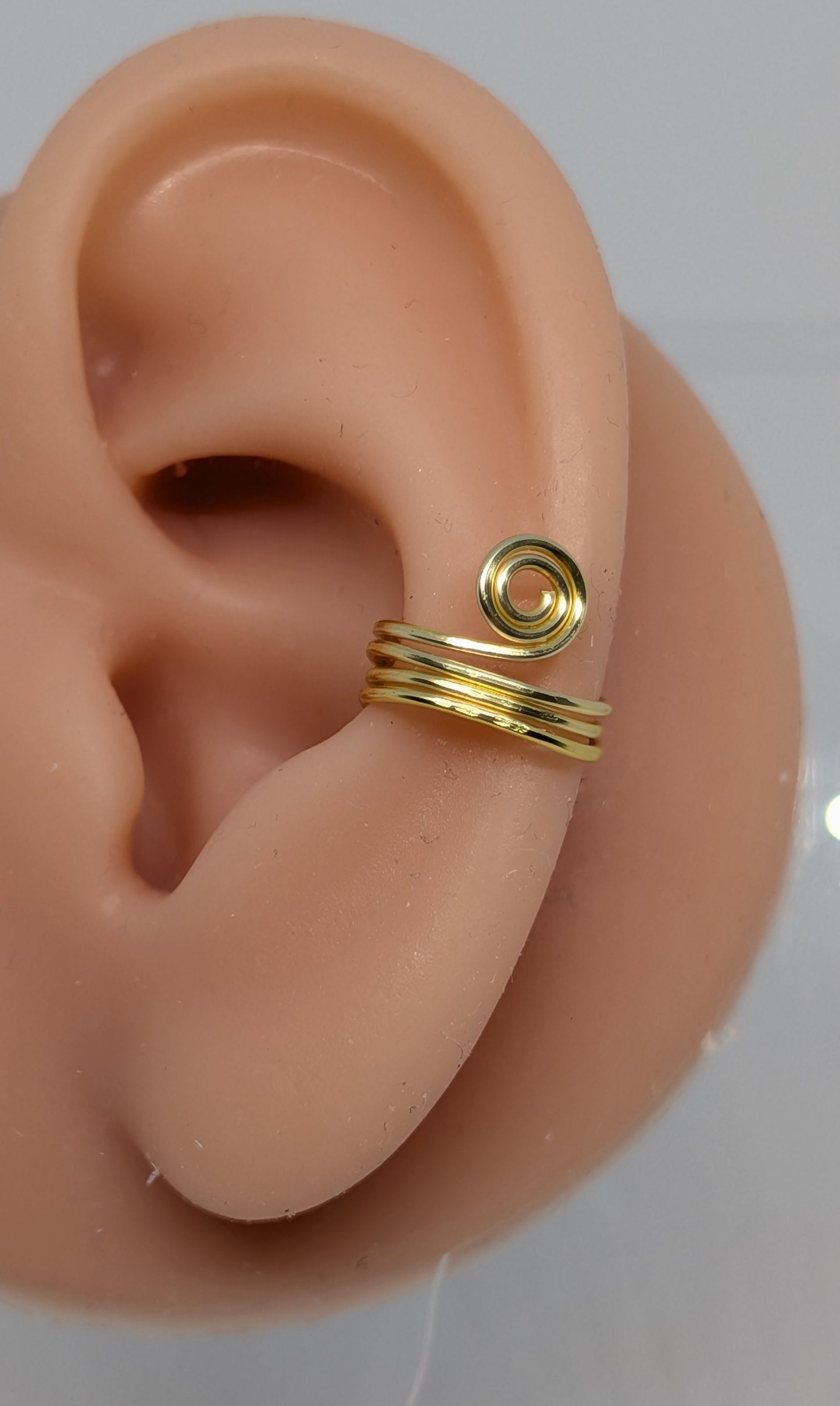 Ein Paar Earcuffs in Hellgold mit dekorativen Spiralen