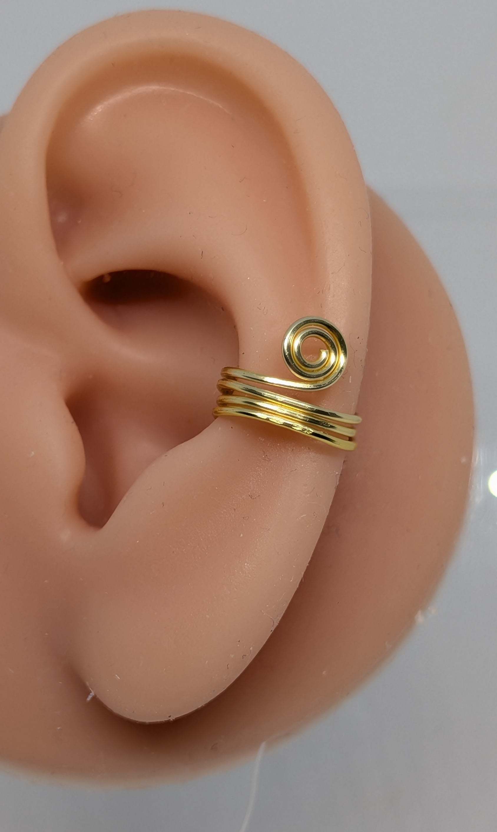 Ein Paar Earcuffs in Hellgold mit dekorativen Spiralen
