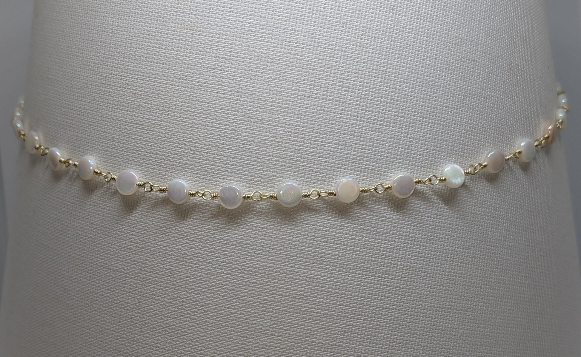 Elegante hellgoldene Kette mit weißen Muschelperlen